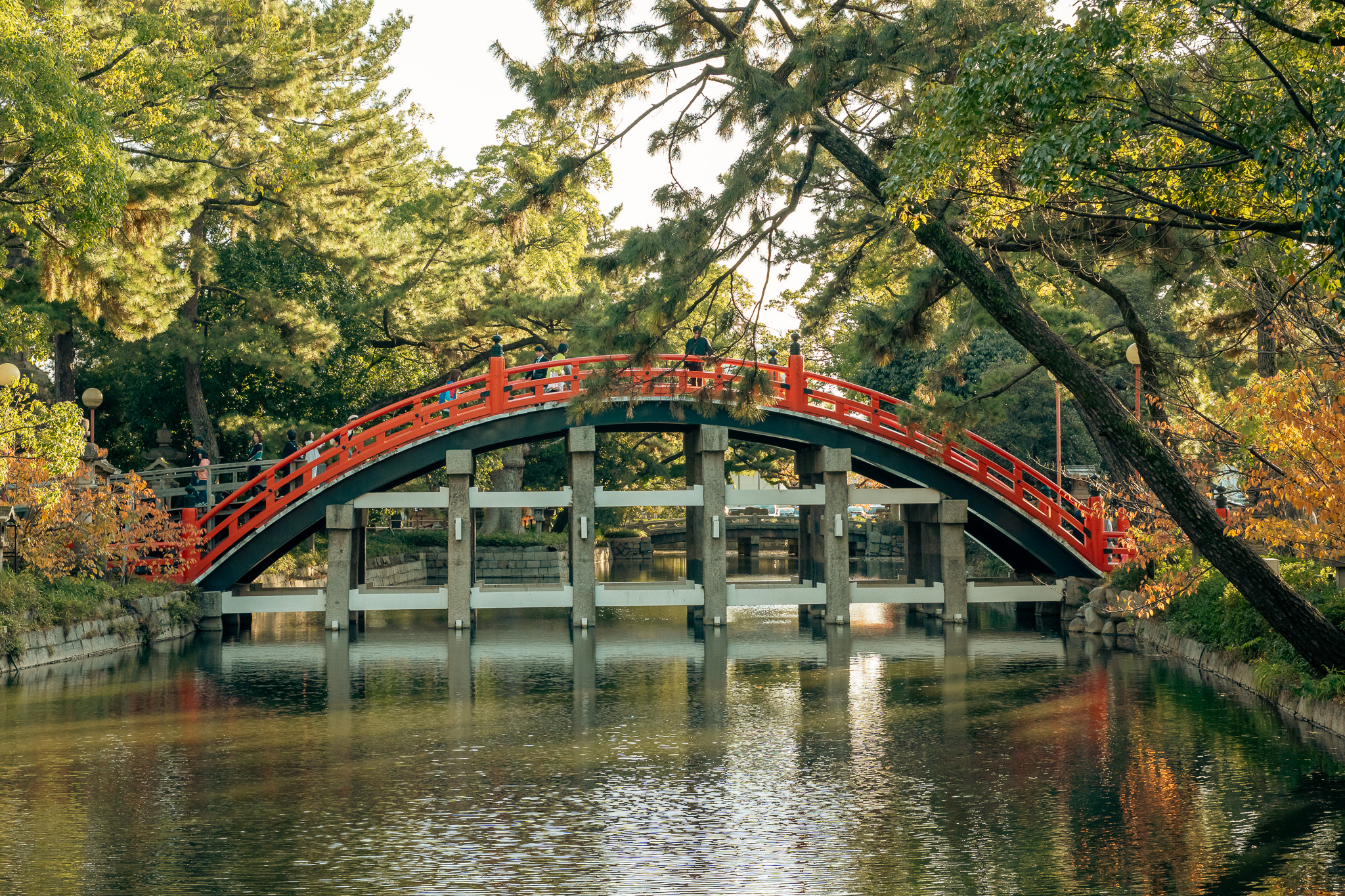 Red drum bridge over water at golden hour